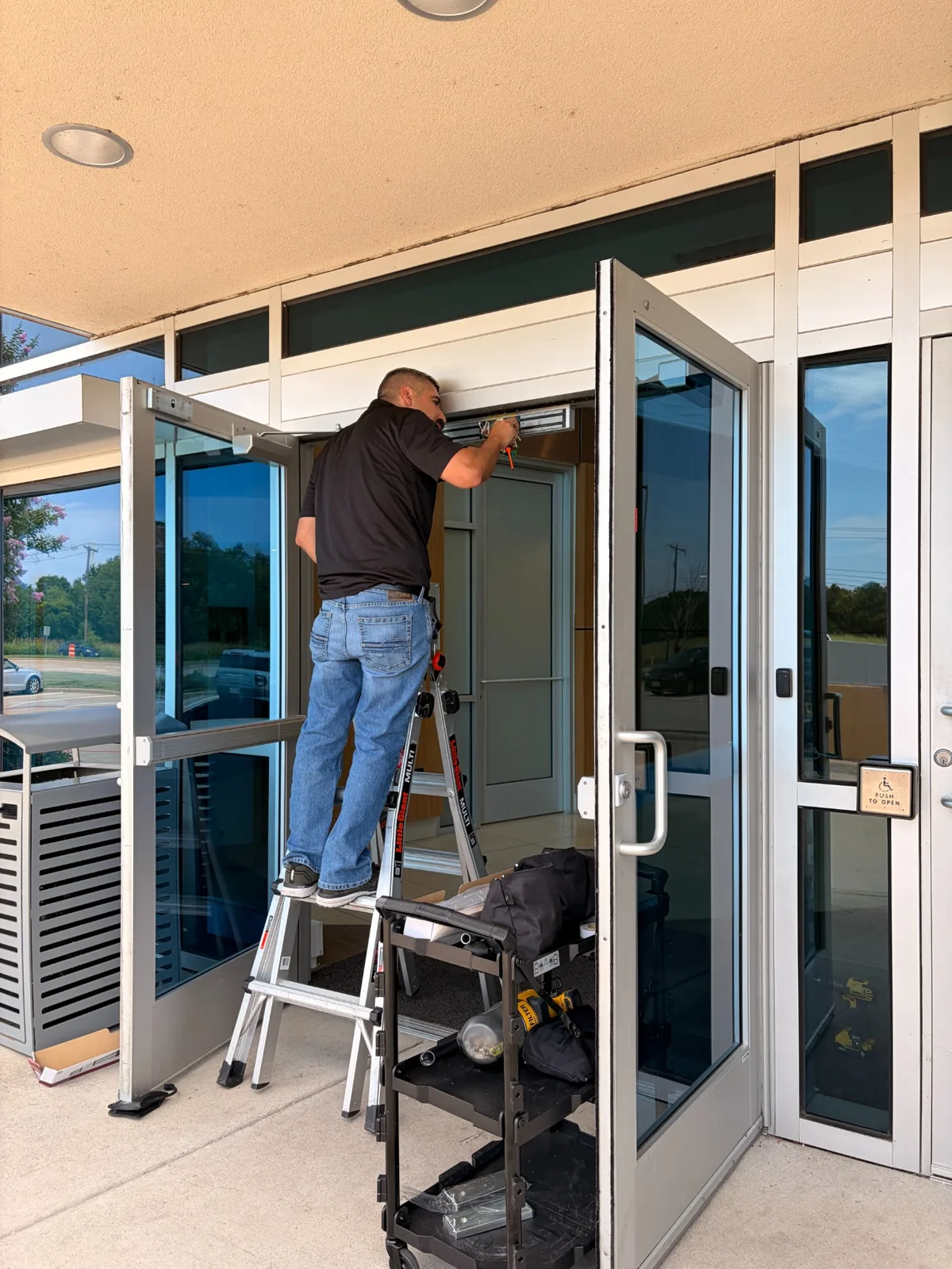 NTEX technician working on a commercial glass entrance