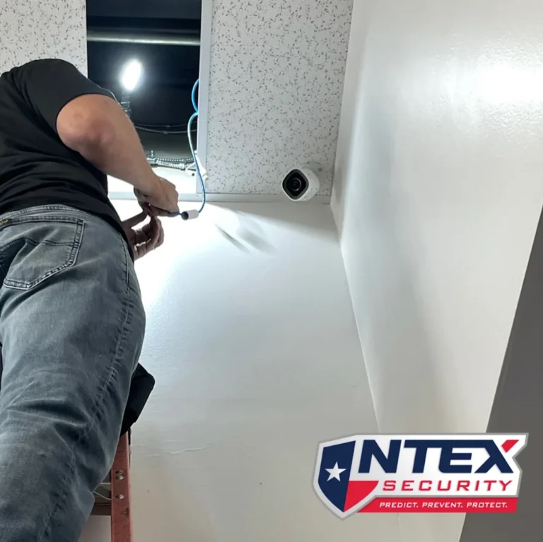 NTEX technician installing a ceiling-mounted security camera